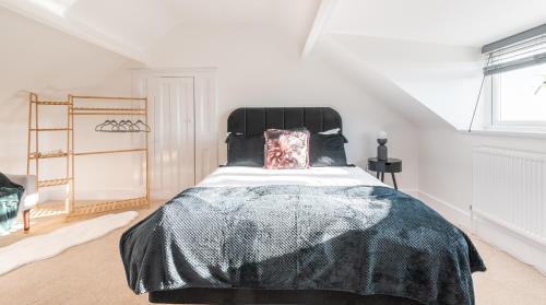a bedroom with a large bed with a black blanket at Tŷ Hapus Newport - Luxury 4 Bedroom Home in Newport