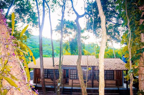 a building in the middle of a forest of trees at Chalé 03 Itaipu Vale da Colina Niterói in Niterói