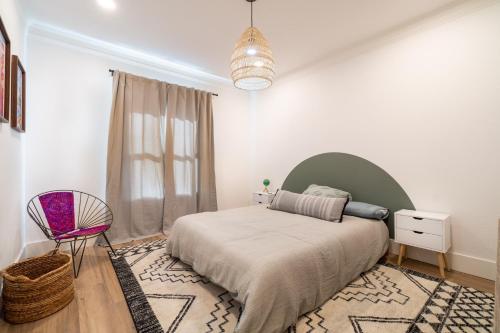 a bedroom with a bed and a chair in it at Plush 2-bed apt in Riverside Heights! in Reno