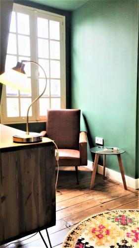 a living room with a chair and a table at Manoir du Bois Mignon in Le Fleix