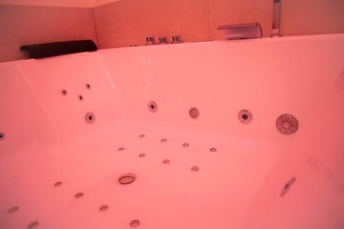 a pink bathtub with a bunch of balls in it at IL PALAZZO - Luxury Home & Event in Cosenza
