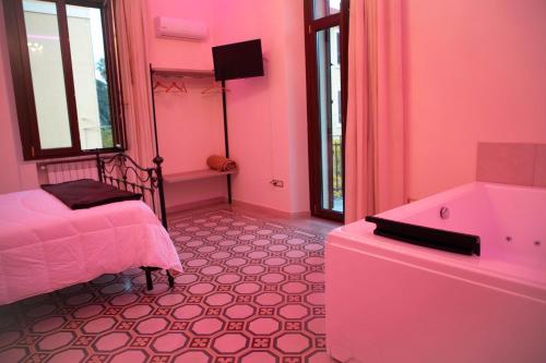 a pink bedroom with a bed and a tub at IL PALAZZO - Luxury Home & Event in Cosenza