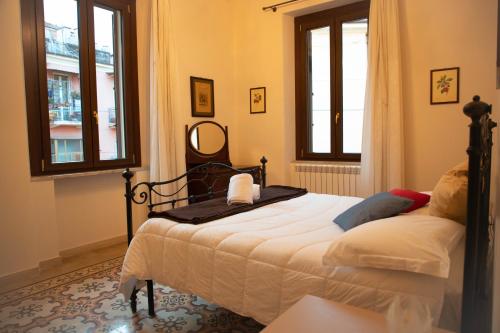 a bedroom with a bed and two windows at IL PALAZZO - Luxury Home & Event in Cosenza