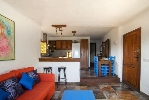 sala de estar con sofá rojo y cocina en Casa de campo mediterránea en Alicante, en Agost