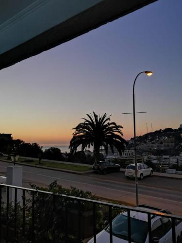 a parking lot with a palm tree and a street light at Departamento La Palmera in Viña del Mar