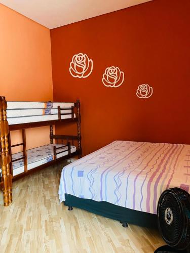 a bedroom with two bunk beds and orange walls at SÍTIO MARAVILHOSO EM MAIRIPORÃ opção de 1 quarto para 8 pessoas ou 4 quartos acima de 9 pessoas in Mairiporã