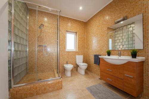 a bathroom with a shower and a sink and a toilet at Casa Petit Paraiso in Lagoa