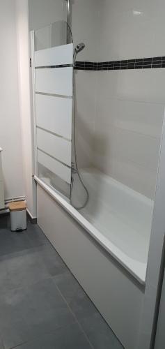 Habitación blanca con baño con ducha. en Appartement-chic parking privé, en Tourcoing
