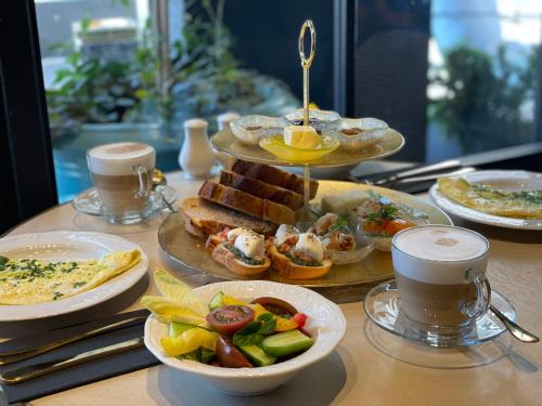 a table topped with plates of food and cups of coffee at Villa Brown Tel-Aviv, a member of Brown Hotels in Tel Aviv