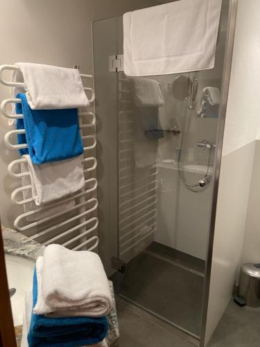 a bathroom with a shower with blue and white towels at Haus Saler in Gaschurn