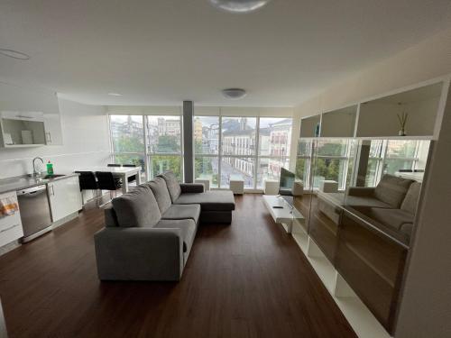 a living room with two couches and a kitchen withwindows at Lugo 360 in Lugo