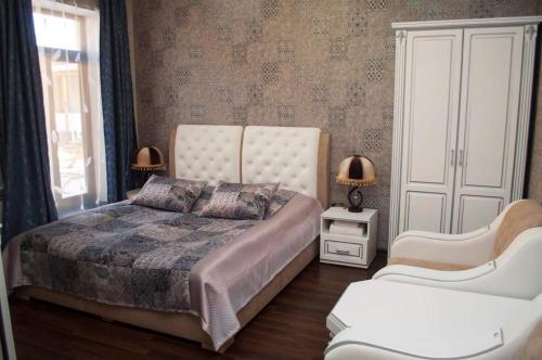 Martuni的住宿－Ahana Hotel in Martuni，一间卧室配有一张大床和两把椅子