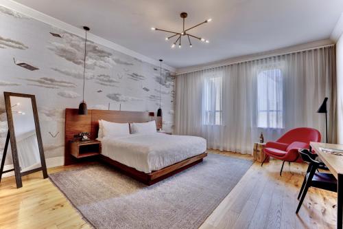 キッチナーにあるThe Walper Hotel, part of JdV by Hyattのベッドとシャンデリアのある寝室