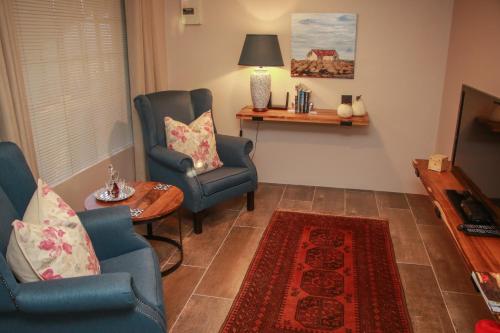 Una sala de estar con dos sillas y una mesa. en Idavold Gate House, en Howick