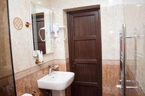 a bathroom with a sink and a wooden door at Ahana Hotel in Martuni in Martuni