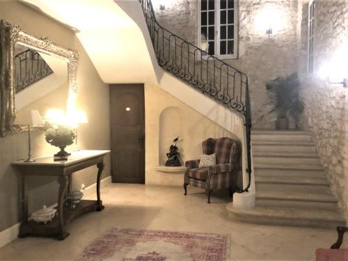 a hallway with a staircase with a chair and a table at Manoir du Bois Mignon in Le Fleix