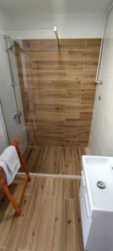 a bathroom with a shower and a wooden floor at Apartments Mare in Hvar