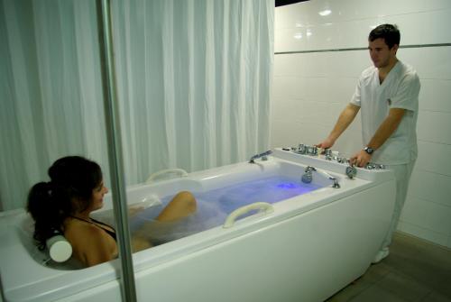 un hombre y una mujer en una bañera en El Salugral Termal Resort, en Hervás