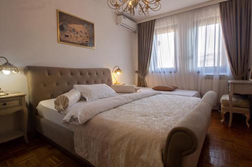 Un dormitorio con una cama grande y una ventana en Apartment Barby - Aleja, en Banja Luka