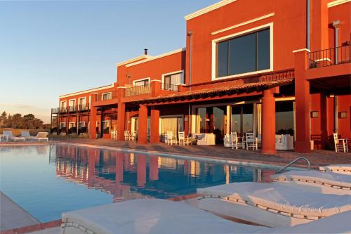 a building with a swimming pool next to a resort at Pampas de Areco Resort de Campo & Spa in San Antonio de Areco