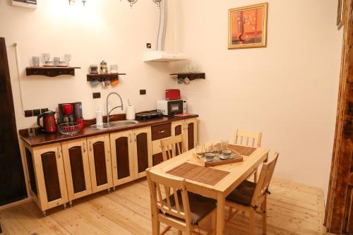 una cucina con tavolo, lavandino, tavolo e sedie di Apartamentul 16 a Braşov