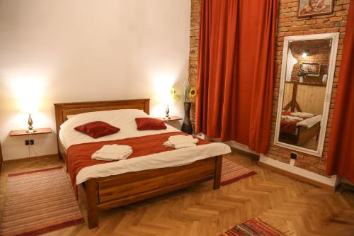 a bedroom with a bed with red curtains and a mirror at Apartamentul 16 in Braşov