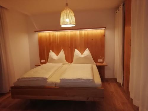 a bedroom with a large bed with a wooden headboard at Haus Meißnitzer in Taxenbach