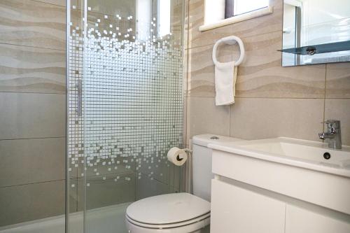 a bathroom with a shower and a toilet and a sink at Familia Brito in Porches