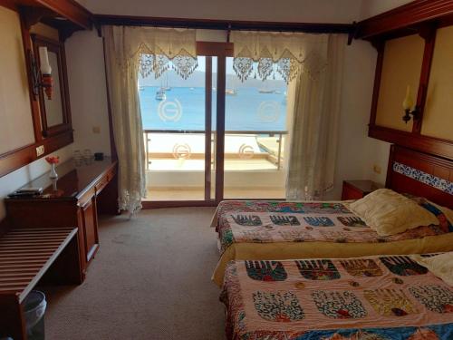 a hotel room with two beds and a large window at Gözen Hotel in Bodrum City