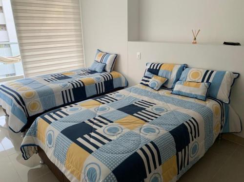 two beds sitting next to each other in a bedroom at Edificio kuali apto 1704 in Santa Marta