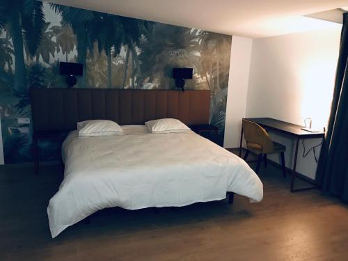 a bedroom with a large white bed and a desk at Hôtel Amaya in Ambarès-et-Lagrave