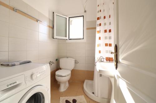 a white bathroom with a toilet and a sink at A Nice Apartment- Corfu Town, Kanoni in Kanoni