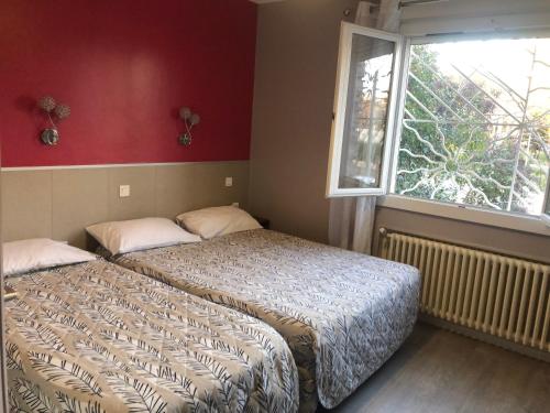 モンペリエにあるHotel les Troenesのベッドルーム1室(ベッド2台、窓付)