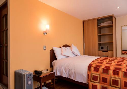 a hotel room with a bed and a television at Laramani Hotel Boutique in Cusco