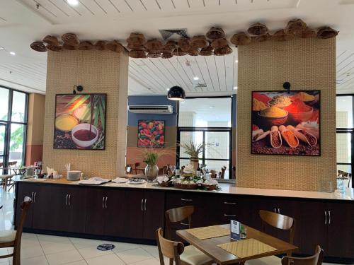 a restaurant with a counter with a table and chairs at Tropical Executive Hotel in Manaus