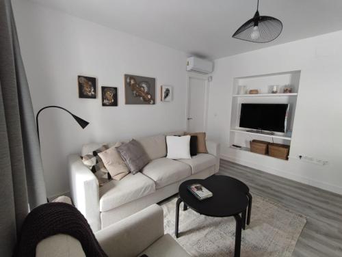 a living room with a couch and a table at ARTE Playa la Caleta Grupo AC Gestion in Cádiz