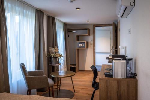 a living room with a table and chairs in a room at Hotel & Restaurant Bären in Niederbipp