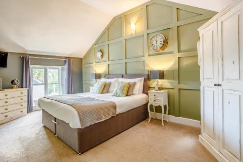a bedroom with a large bed with a green wall at Broadrock Accommodation - Clock Cottage in Chepstow