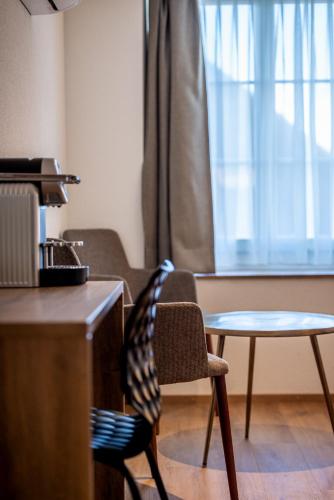 a chair and a table in a room at Hotel & Restaurant Bären in Niederbipp