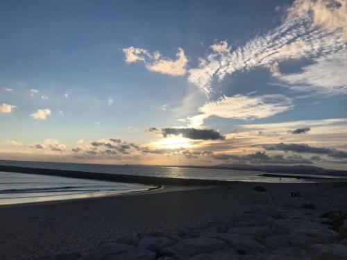 a beach with a cloudy sky and the ocean at T2 com uma vista deslumbrante sobre o Atlântico! in Costa da Caparica