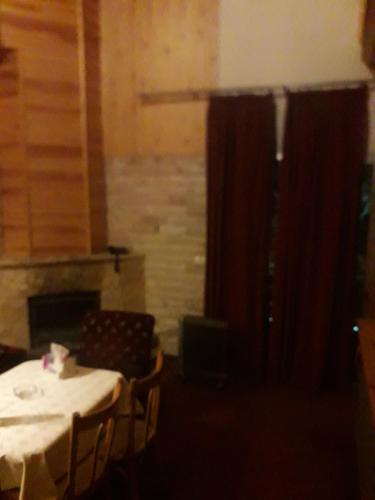 a table and chairs in a room with a fireplace at Tamerland-faraya in Fārayyā