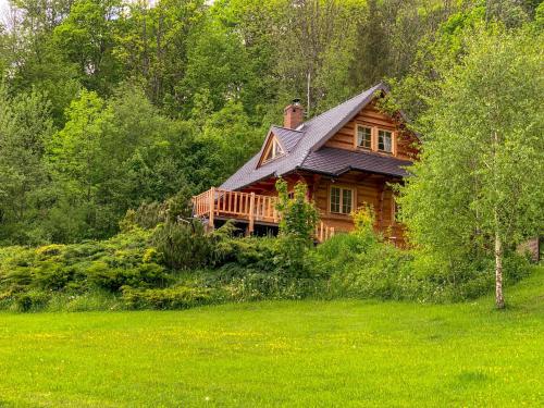 a wooden house in the middle of a field at Leśne uroczysko in Cisna