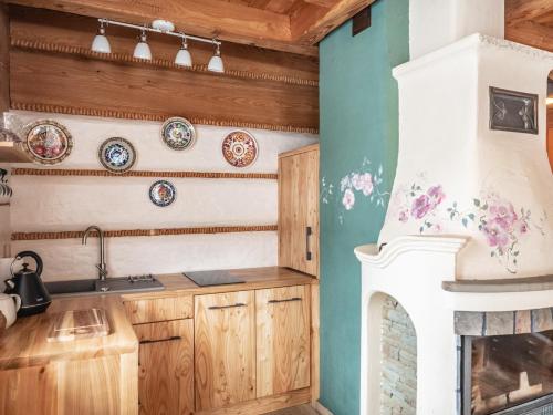 a kitchen with a fireplace and plates on the wall at Leśne uroczysko in Cisna