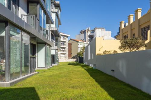 an alley between two buildings with green grass at Habitatio - Bom Sucesso by LuxiStay in Porto
