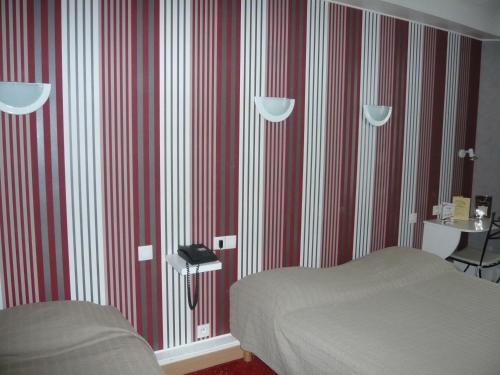 a bedroom with red and white striped walls and a bed at Hôtel - Restaurant Saint Jacques in Blois