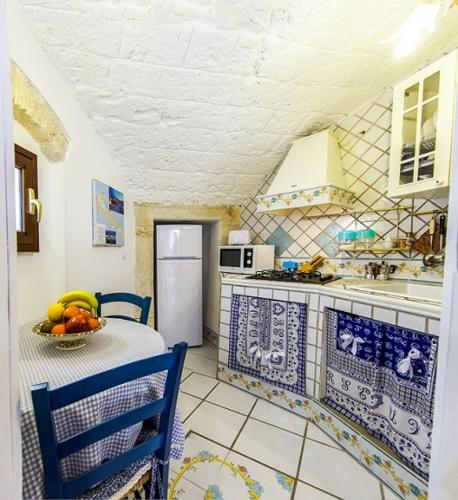 a kitchen with a table with a bowl of fruit on it at Anna's Rose Holiday Home in Monopoli