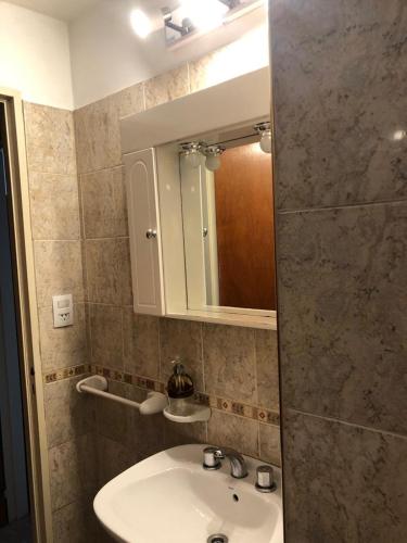 a bathroom with a sink and a mirror at Departamento Alberdi Completo con Cochera in Córdoba