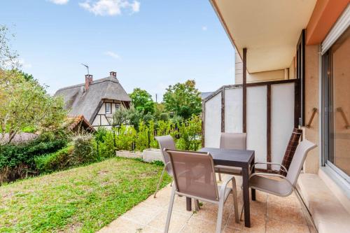 un patio avec une table et des chaises sur un balcon dans l'établissement Studio Aristide - Welkeys, à Cabourg