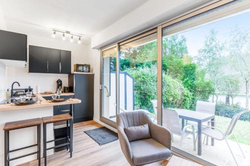 une cuisine ouverte et une salle à manger avec une table et une chaise dans l'établissement Studio Aristide - Welkeys, à Cabourg