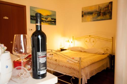 a bottle of wine sitting on a table next to a bed at Anna's Rose Holiday Home in Monopoli